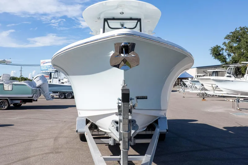 Slide: The Image of 2025 Sea Hunt Ultra 245 SE boat on trailer at dealership under clear sky. - 25