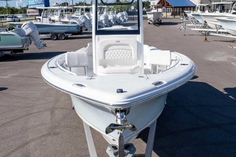 Slide: The Image of 2025 Sea Hunt Ultra 245 SE boat displayed at dealership, showcasing sleek design and spacious seating. - 27