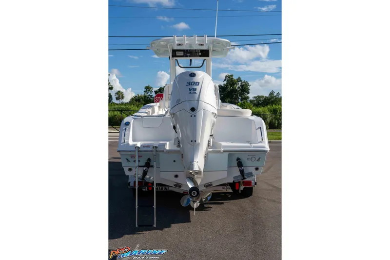 Slide: The Image of 2025 Sea Hunt Ultra 245 SE boat with powerful outboard motor, parked on a sunny day. - 30
