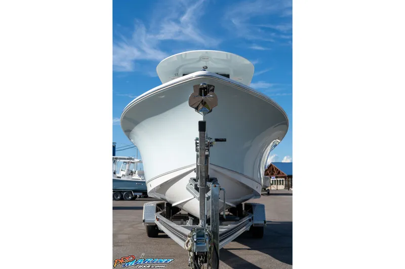 Slide: The Image of 2025 Sea Hunt Ultra 245 SE boat on trailer under clear blue sky. - 36