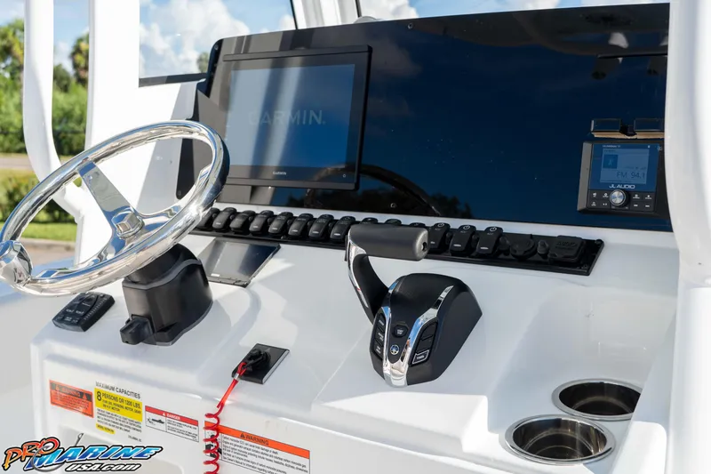 Slide: The Image of 2025 Sea Hunt Ultra 245 SE boat dashboard with Garmin display and controls. - 45