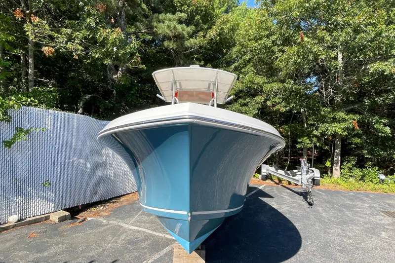 Slide: The Image of 2014 Sailfish 220 CC boat on trailer, surrounded by trees and a fence. - 1