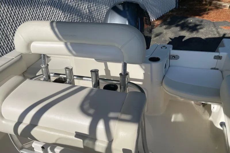 Slide: The Image of 2014 Sailfish 220 CC boat interior with white seating and rod holders. - 10