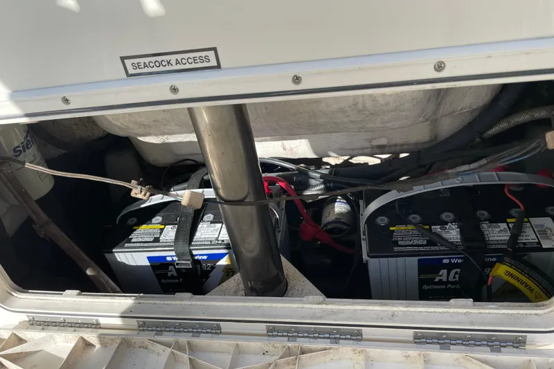Slide: The Image of 2014 Sailfish 220 CC seacock access with marine batteries and wiring. - 12