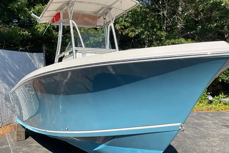 Slide: The Image of 2014 Sailfish 220 CC boat with blue hull, parked outdoors. - 3