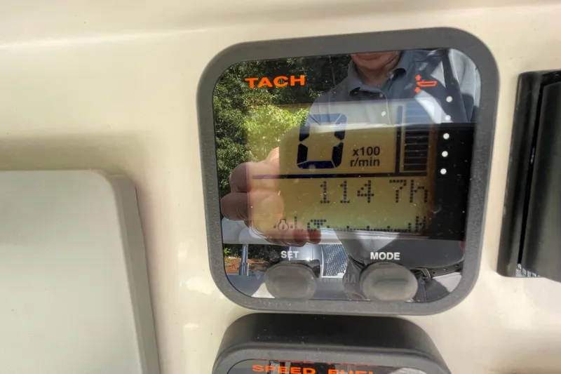 Slide: The Image of Tachometer display on 2014 Sailfish 220 CC boat showing 114.7 hours. - 6