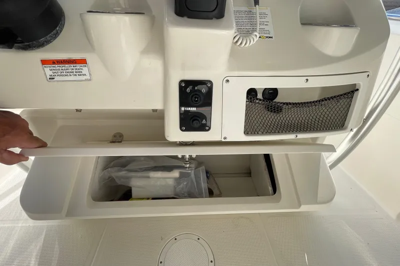 Slide: The Image of 2014 Sailfish 220 CC boat console with storage compartment and Yamaha controls. - 7