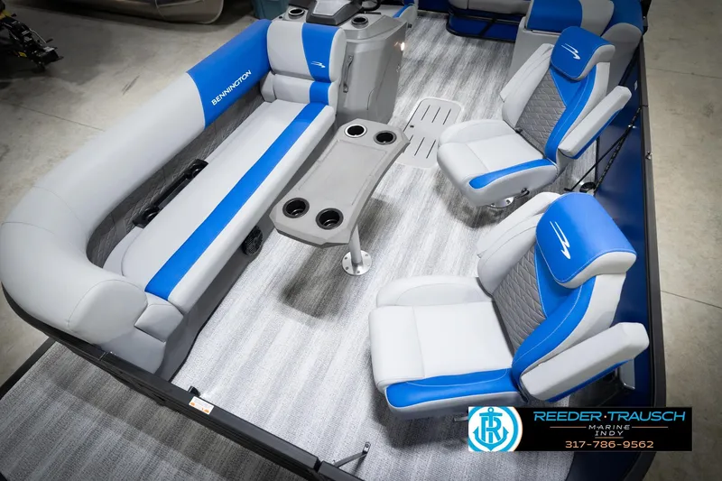 Slide: The Image of 2026 Bennington 22 SSB pontoon boat interior with blue and gray seating, showcased by Reeder-Trausch Marine. - 12