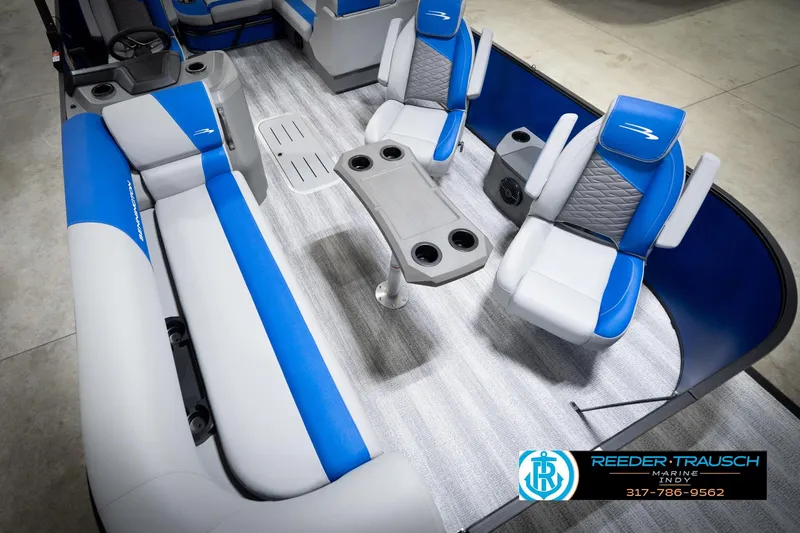 Slide: The Image of 2026 Bennington 22 SSB pontoon boat interior with blue and gray seating, Reeder-Trausch Marine logo. - 13