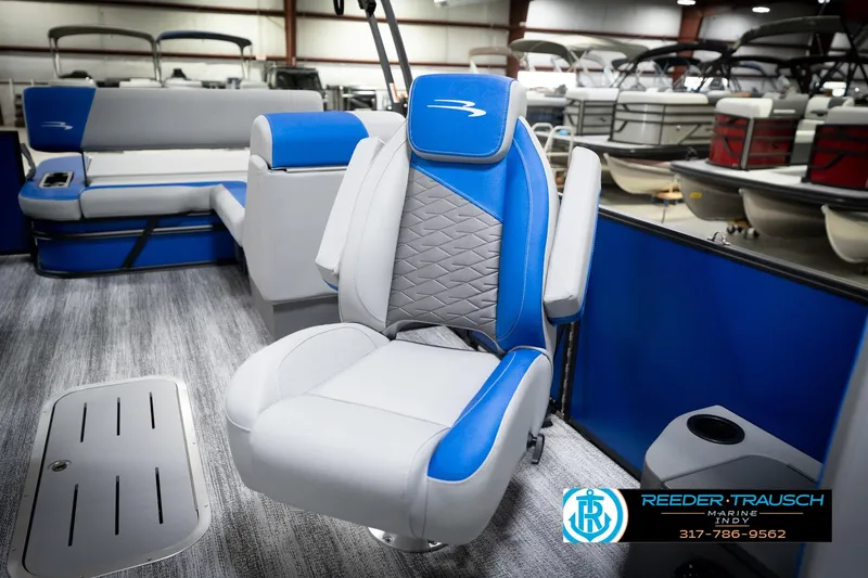 Slide: The Image of 2026 Bennington 22 SSB pontoon boat interior with blue and gray seating in showroom. - 24