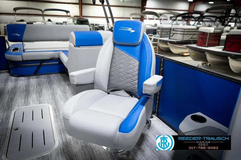 Slide: The Image of 2026 Bennington 22 SSB pontoon boat interior with blue and white seating in showroom. - 25