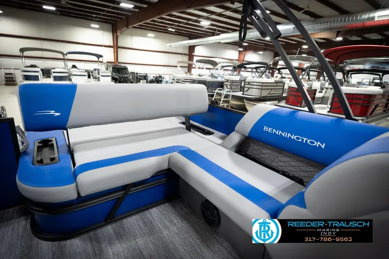 Slide: The Image of 2026 Bennington 22 SSB pontoon boat interior with blue and gray seating in showroom. - 26
