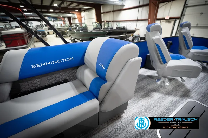 Slide: The Image of 2026 Bennington 22 SSB pontoon boat interior with blue and gray seating in showroom. - 29