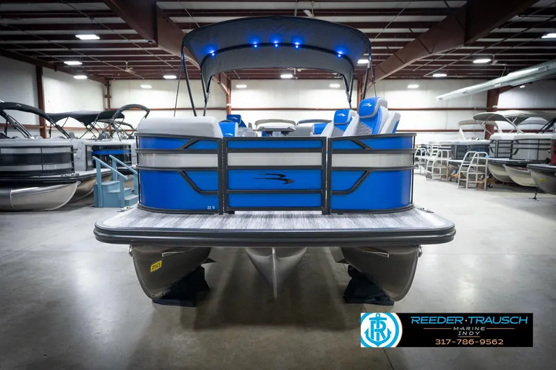 Slide: The Image of 2026 Bennington 22 SSB pontoon boat in showroom, blue and silver design, Reeder-Trausch Marine. - 5