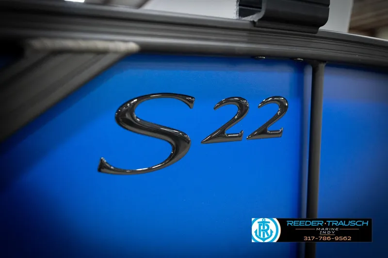 Slide: The Image of 2026 Bennington 22 SSB boat, blue exterior with "S 22" emblem, Reeder-Trausch Marine logo. - 60