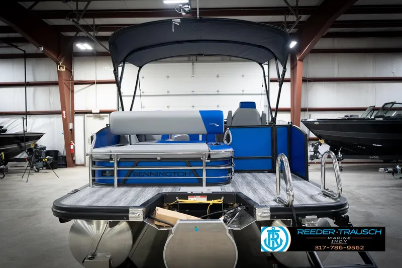 Slide: The Image of 2026 Bennington 22 SSB pontoon boat in showroom, featuring sleek blue design. - 9
