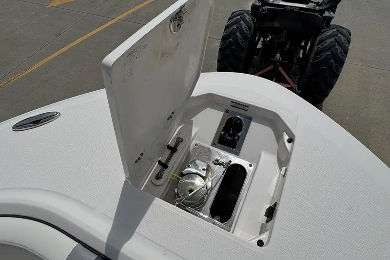 Slide: The Image of 2023 Robalo R250 Center Console boat anchor compartment open on deck. - 10