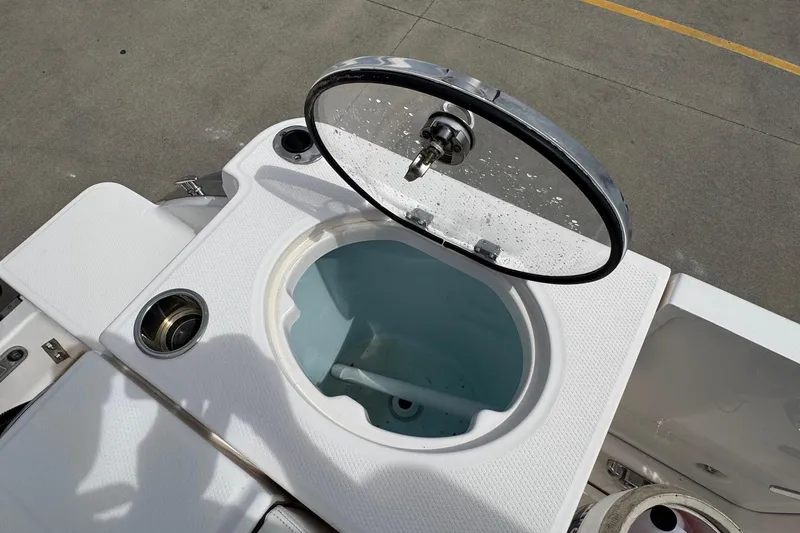Slide: The Image of 2023 Robalo R250 Center Console livewell with open lid, showcasing interior design. - 19