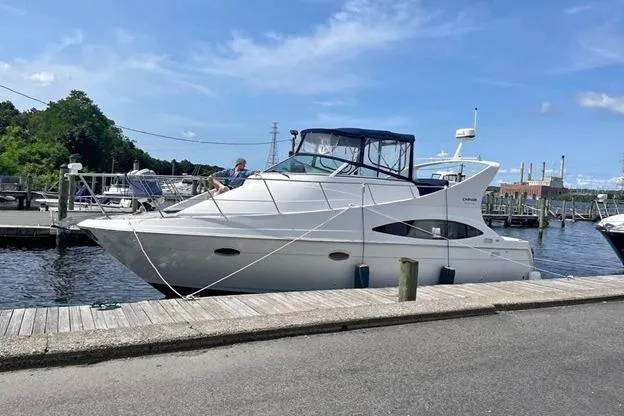 The Image of 1999 Carver Mariner 350 yacht docked at a marina under a clear blue sky. - 0