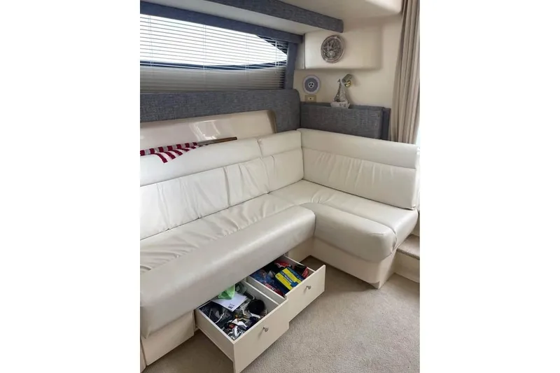 Slide: The Image of Interior of 1999 Carver Mariner 350 yacht with white leather seating and storage drawers open. - 12