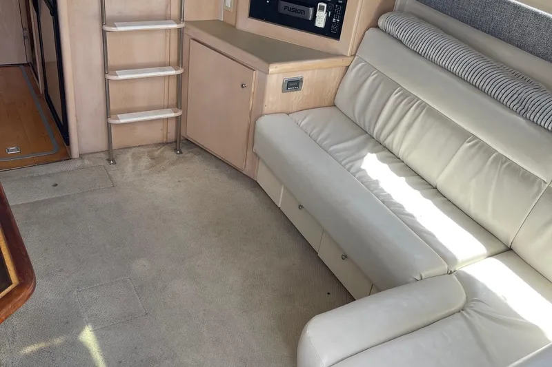 Slide: The Image of Interior of 1999 Carver Mariner 350 yacht with white leather seating and carpeted floor. - 9