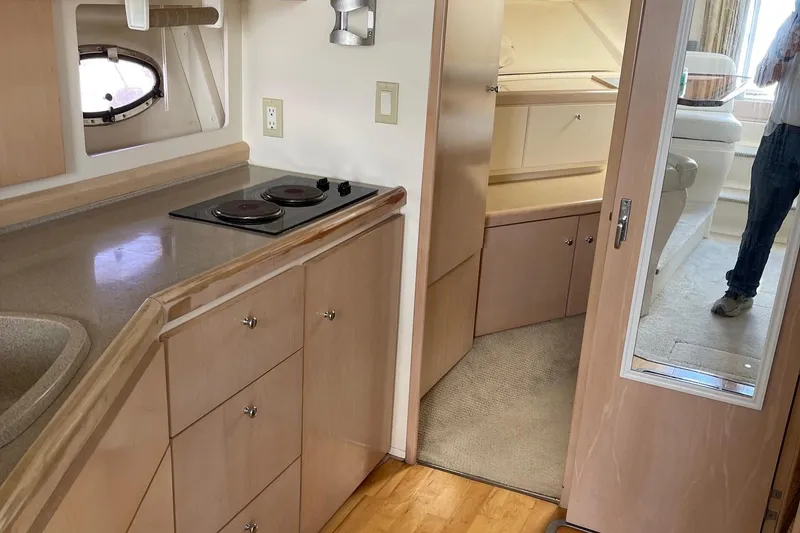 Slide: The Image of 1999 Carver Mariner 350 interior with kitchenette, stove, and cabinetry. - 13
