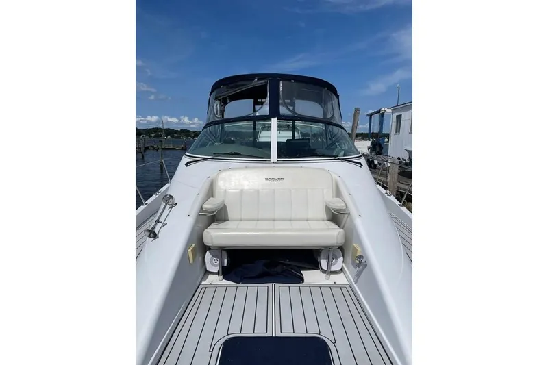 Slide: The Image of 1999 Carver Mariner 350 yacht with white seating, docked under a clear blue sky. - 7