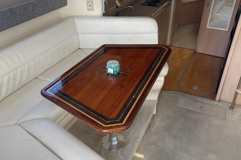 Slide: The Image of Interior of 1999 Carver Mariner 350 with elegant wooden table and white seating. - 10