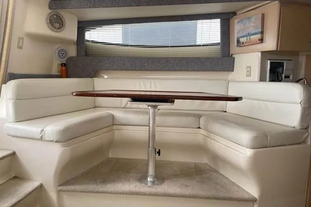 Slide: The Image of 1999 Carver Mariner 350 interior with white seating and wooden table. - 11
