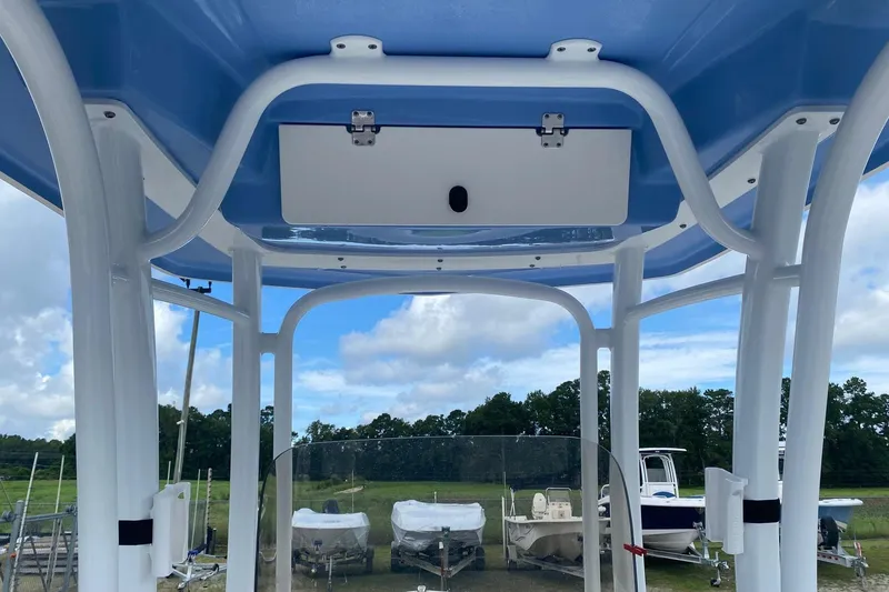 Slide: The Image of 2023 Robalo R222 Explorer boat interior with blue and white canopy, outdoor setting. - 11