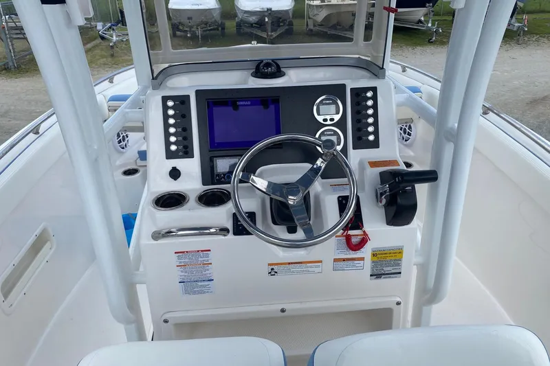 Slide: The Image of 2023 Robalo R222 Explorer boat dashboard with steering wheel and navigation controls. - 12