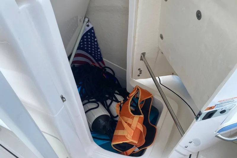Slide: The Image of Storage compartment of 2023 Robalo R222 Explorer with life jacket and American flag. - 14