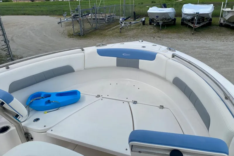 Slide: The Image of 2023 Robalo R222 Explorer boat interior with blue and gray seating, docked outdoors. - 4