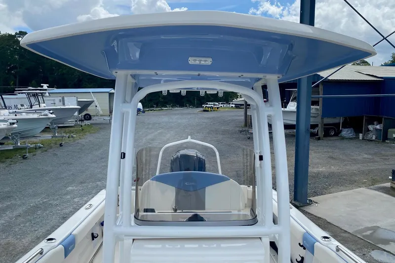 Slide: The Image of 2023 Robalo R222 Explorer boat with T-top, parked in a marina. - 6