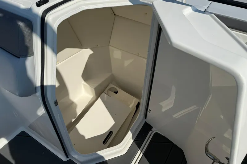 Slide: The Image of 2025 Bayliner D22I boat interior storage compartment, open door, white finish. - 13
