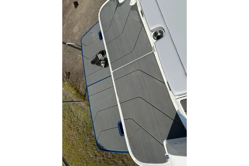 Slide: The Image of 2025 Bayliner D22I boat deck with gray non-slip surface and blue trim. - 20