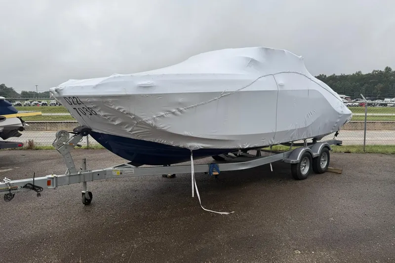 Slide: The Image of 2025 Bayliner D22I boat covered on a trailer in a parking lot. - 24