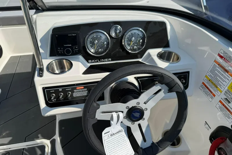 Slide: The Image of 2025 Bayliner D22I boat dashboard with steering wheel, gauges, and control panel. - 3