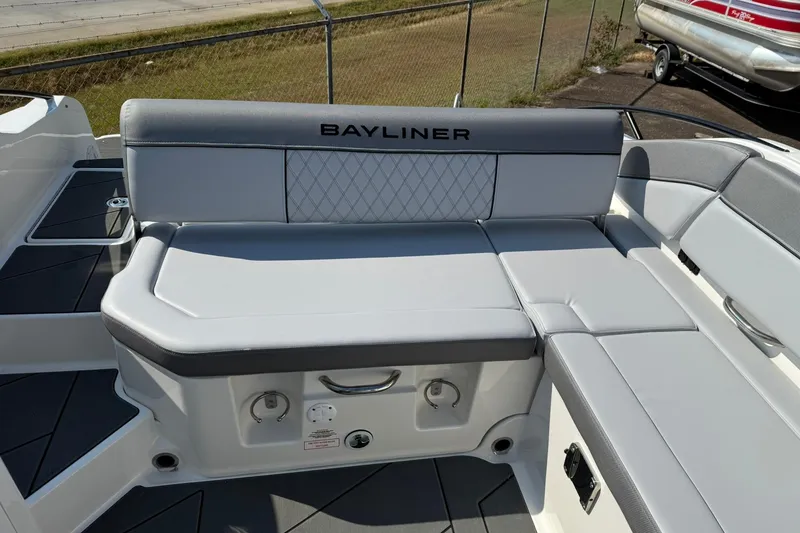 Slide: The Image of 2025 Bayliner D22I boat interior with gray cushioned seating and storage compartment. - 6