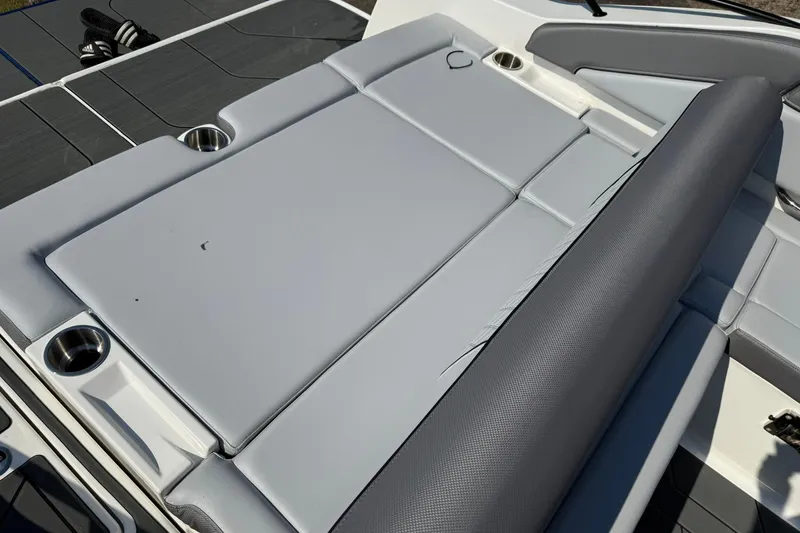 Slide: The Image of 2025 Bayliner D22I boat interior with gray cushioned seating and cup holders. - 8