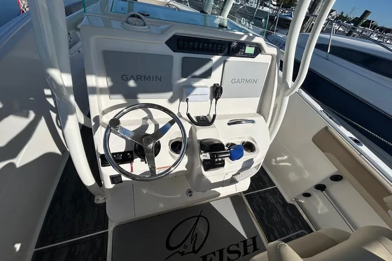 Slide: The Image of 2019 Sailfish 270 CC boat cockpit with Garmin navigation system and steering wheel. - 13