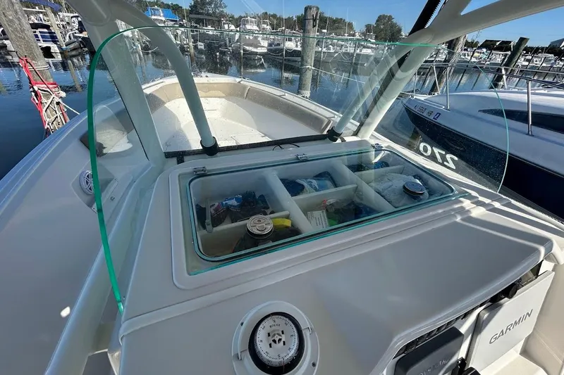 Slide: The Image of 2019 Sailfish 270 CC boat with storage compartments, docked at a marina. - 14