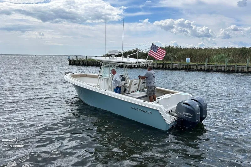 Slide: The Image of 2019 Sailfish 270 CC boat with dual Yamaha engines on a calm waterway. - 2