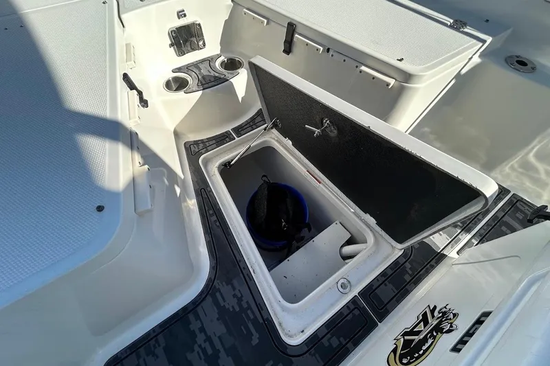 Slide: The Image of 2019 Sailfish 270 CC boat interior with open storage compartment and cup holders. - 20