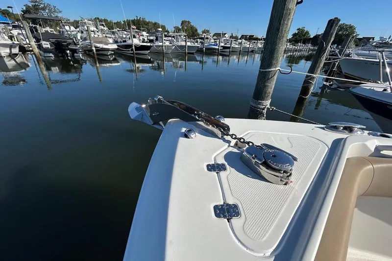 Slide: The Image of 2019 Sailfish 270 CC boat anchored at a marina, showcasing anchor and deck details. - 21