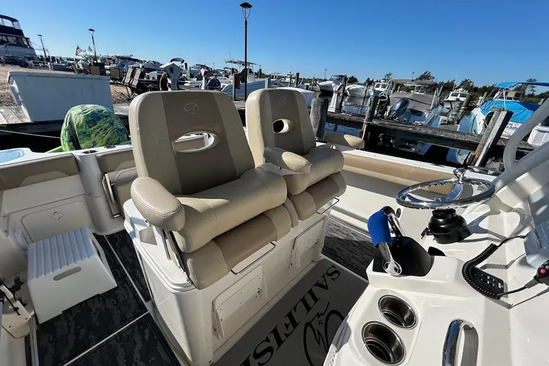 Slide: The Image of 2019 Sailfish 270 CC boat interior with dual captain's chairs and steering wheel. - 25