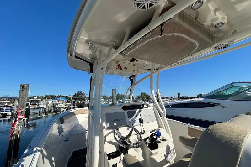 Slide: The Image of 2019 Sailfish 270 CC boat interior with Garmin navigation, docked at marina under clear blue sky. - 26