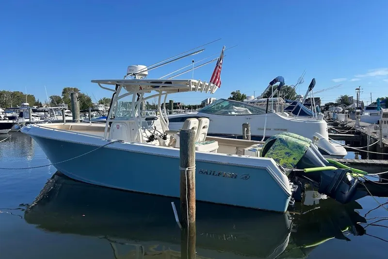 Slide: The Image of 2019 Sailfish 270 CC boat docked in marina under clear blue sky. - 4