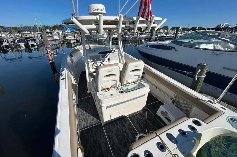 Slide: The Image of 2019 Sailfish 270 CC boat docked at marina, featuring Garmin equipment and spacious seating. - 8
