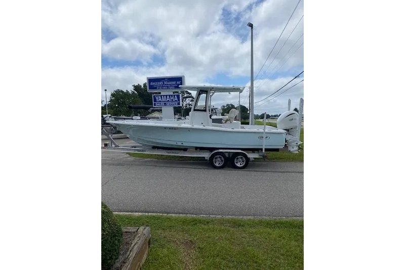 Slide: The Image of 2024 Sea Hunt BX 25 FS boat on trailer, parked near Yamaha sales sign. - 1